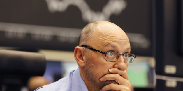 A trader watches his screens when the curve of the German stock index DAX fell under 10,000 points at the stock market in Frankfurt, Germany, Monday, Aug. 24, 2015. (AP Photo/Michael Probst)