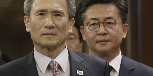 South Korean presidential security adviser Kim Kwan-jin, left, and Unification Minister Hong Yong-pyo arrive to hold a press conference at the presidential house in Seoul, South Korea, Tuesday, Aug. 25, 2015. South Korea has agreed to halt propaganda broadcasts at noon Tuesday after North Korea expressed regret over a recent land mine blast that maimed two South Korean troops, both Koreas announced after three days of intense talks aimed at defusing soaring tension between the rivals.(AP Photo/A
