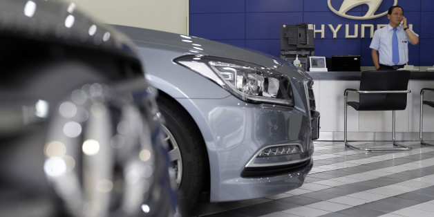 An employee of Hyundai Motor Co. works at the company's showroom in Seoul, South Korea, Thursday, July 23, 2015. Hyundai Motor Co. says its second quarter earnings sank 24 percent due to a sales drop in China and weakness in other markets due to falling currencies.(AP Photo/Ahn Young-joon)