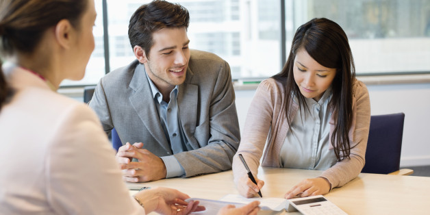 Couple signing documents with real estate agent