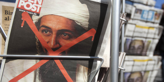 People pass newspapers front pages with the report of Osama bin Laden's death, at a newsstand in Berlin Tuesday, May 3, 2011. Osama bin Laden, the mastermind behind the Sept. 11, 2001, terror attacks that killed thousands of Americans, was killed in an operation led by the United States, President Barack Obama said Sunday. The letters at the Hamburger Morgenpost newspaper left reads : 'Headshot at Luxus-Villa' . (AP Photo/Markus Schreiber)