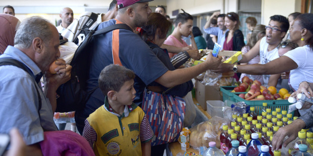 People receive food after they arrived at a railway station in Vienna, Austria, on Tuesday, Sept. 1, 2015. Some hundreds of migrants arrived by train from southern Europe, after making a perilous journey into Europe. (AP Photo/Hans Punz)