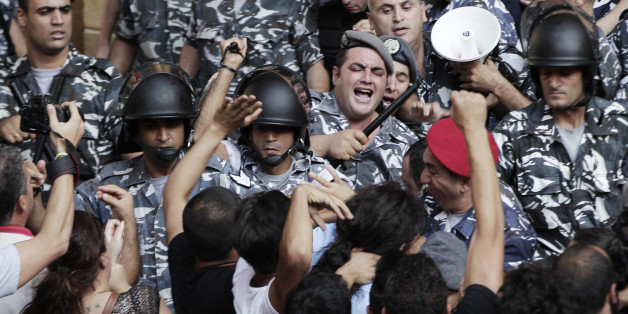 Lebanese anti-government protesters clashes with policemen outside the Environment Ministry in support of activists staging a sit-in inside, in downtown Beirut, Lebanon, Tuesday, Sept. 1, 2015. Lebanese security forces dragged a number of activists out of the Environment Ministry in downtown Beirut, where they were staging an hours-long sit-in on Tuesday demanding the minister's resignation over a trash crisis that has ignited mass protests. (AP Photo/Bilal Hussein)