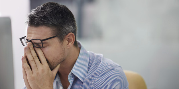 A cropped shot of a stressed businessman sitting at his desk