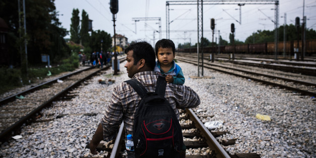 Un migrant et son fils sur la route de Gevgelija, une ville à la frontière de la Grèce et de la Macédoine, le 3 août
