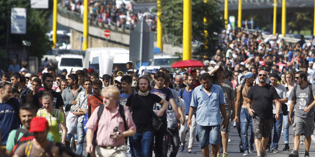 Migrants walk along the Hegyalja Street in Budapest, Hungary, Friday, Sept. 4, 2015. Several thousand migrants left the Keleti railway station in Budapest this afternoon heading for Germany on foot. (Zsolt Szigetvary/MTI via AP) )