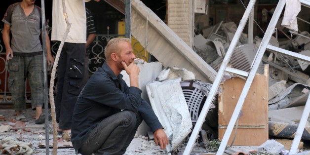 DAMASCUS, SYRIA - SEPTEMBER 02: Syrians are seen on the rubble of buildings after the war crafts belonging to the Syrian army bombed a residential area in Hamoryah neighborhood of eastern Ghouta in Damascus, Syria on September 2, 2015. (Photo by Yousef Homms/Anadolu Agency/Getty Images)
