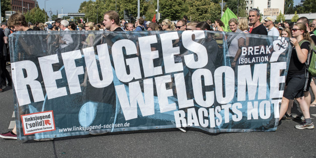Protesters demonstrate with a banner 'Refugees welcome!' in Dresden, eastern Germany, Saturday, Aug. 29, 2015. A refugee shelter was attacked by far-right protesters in Heidenau near Dresden over the last weekend. (AP Photo/Jens Meyer)
