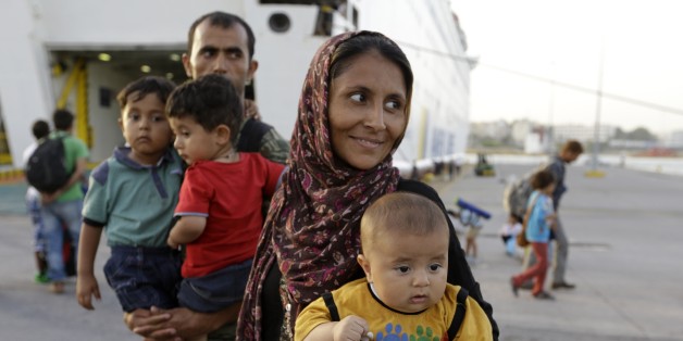 A family from Afghanistan arrives from the northeastern Greek island of Lesbos to the Athens' port of Piraeus on Monday, Sept. 7, 2015. About 2,500 people arrived with the ferry Eleftherios Venizelos as Frontex, the EU border agency, says more than 340,000 asylum seekers have entered the 28-nation bloc this year, the majority fleeing war and human rights abuses in Syria, Afghanistan, Iraq, Somalia and Eritrea. (AP Photo/Thanassis Stavrakis)
