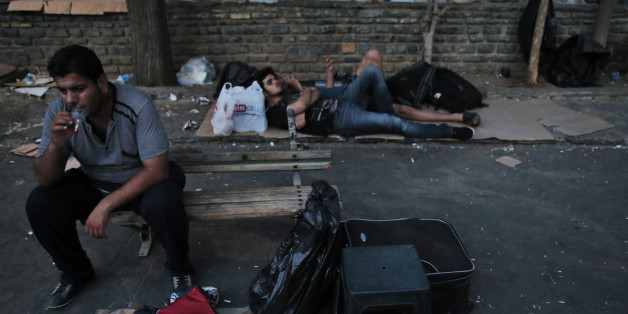 Syrian migrant Eyad Saleh, 35, smokes as he sits with a life jacket, on a park where him and his family spend their time, waiting for the chance to cross with boats to the nearby Greek island of Kos, on the coastal town of Bodrum, Turkey, Thursday, Aug. 13, 2015. Saleh says his three and a half year old daughter Maria, who suffers from Down syndrome and eating disorder, has to get to Europe in order to get proper medical treatment. Greece has become the main gateway to Europe for tens of thousan
