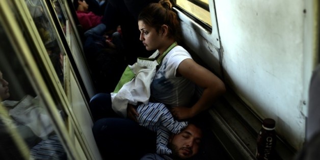 Des réfugiés irakiens Ahmad, Alia et leur bébé Adam voyagent, le 30 août 2015 dans un train de la Macédoine à la Serbie, dans le cadre de leur périple pour rejoindre l'Allemagne