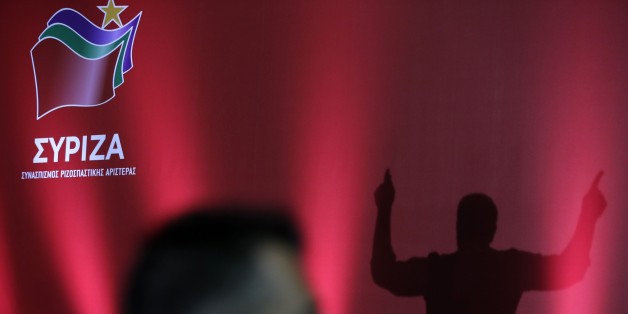 Syriza's leader, former prime minister Alexis Tsipras is silhouetted on a stage as a security stands guard during his a pre-election speech in western Athens, Thursday, Sept. 3, 2015. A new opinion poll suggests that Greece's former governing radical left party has dropped marginally behind the main opposition conservatives in popularity, for the first time since it gained power in January. Greeks vote in parliamentary elections Sept. 20. (AP Photo/Thanassis Stavrakis)