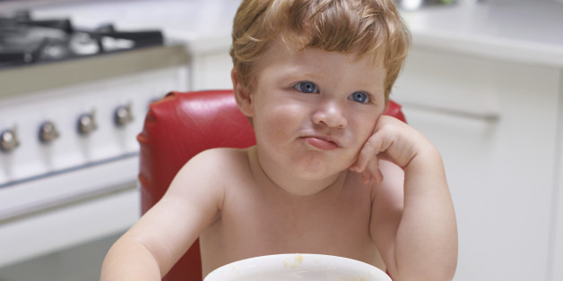 A bored toddler sitting in a high chair