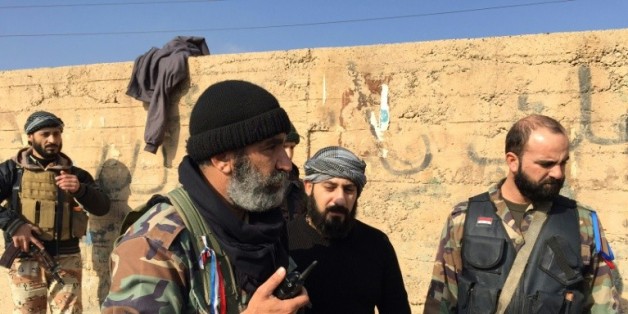 L'armée et des troupes pro-Assad, le 12 décembre 2014 dans la ville de Deir Ezzor, dans le nord-est de la Syrie, cinq jours après avoir repoussé une attaque du groupe islamique (EI) sur l'aéroport, une base stratégique pour le régime de Bachar al-Assad