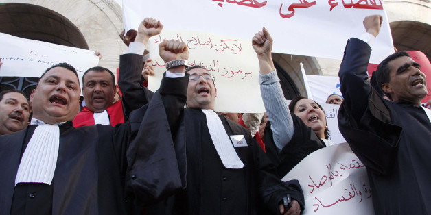 Tunisian magistrates and lawyers demonstrate as they ask for independence of the Judiciary system in Tunis, Tunisia, Saturday Feb. 12, 2011. The banner reads : "Down to the corruption within magistrates". (AP Photo/Hassene Dridi)