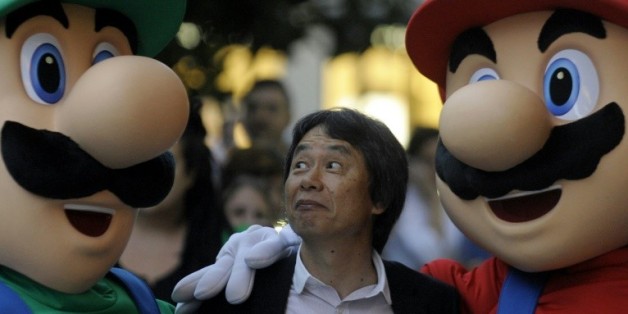 Le créateur de jeux vidéo japonais Shigeru Miyamoto (C), pose avec le célèbre "Super Mario" (D) et son frère Luigi (G), le 25 octobre 2012 à Gijon (Espagne)
