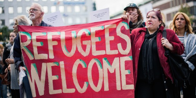 People hold a banner 'refugees welcome' as they take part in a demonstration in solidarity with refugees seeking asylum in Europe after fleeing their home countries in Stockholm on September 12, 2015. AFP PHOTO/JONATHAN NACKSTRAND (Photo credit should read JONATHAN NACKSTRAND/AFP/Getty Images)
