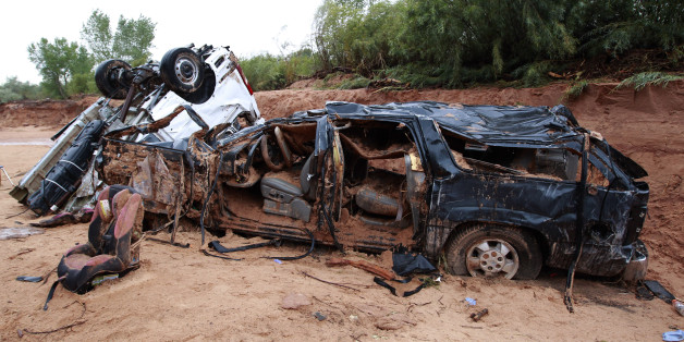 HILDALE, UT - SEPTEMBER 15: The twisted wreckage of two vans that were washed away in a flash flood with women and children inside rest on the bank of Short Creek on September 15, 2015 in Hildale, Utah. Flash Floods from heavy rains on the afternoon of September 14, 2015 washed away two vans in Hildale as they were crossing a flooded creek, killing 12 people with one still missing. (Photo by George Frey/Getty Images)