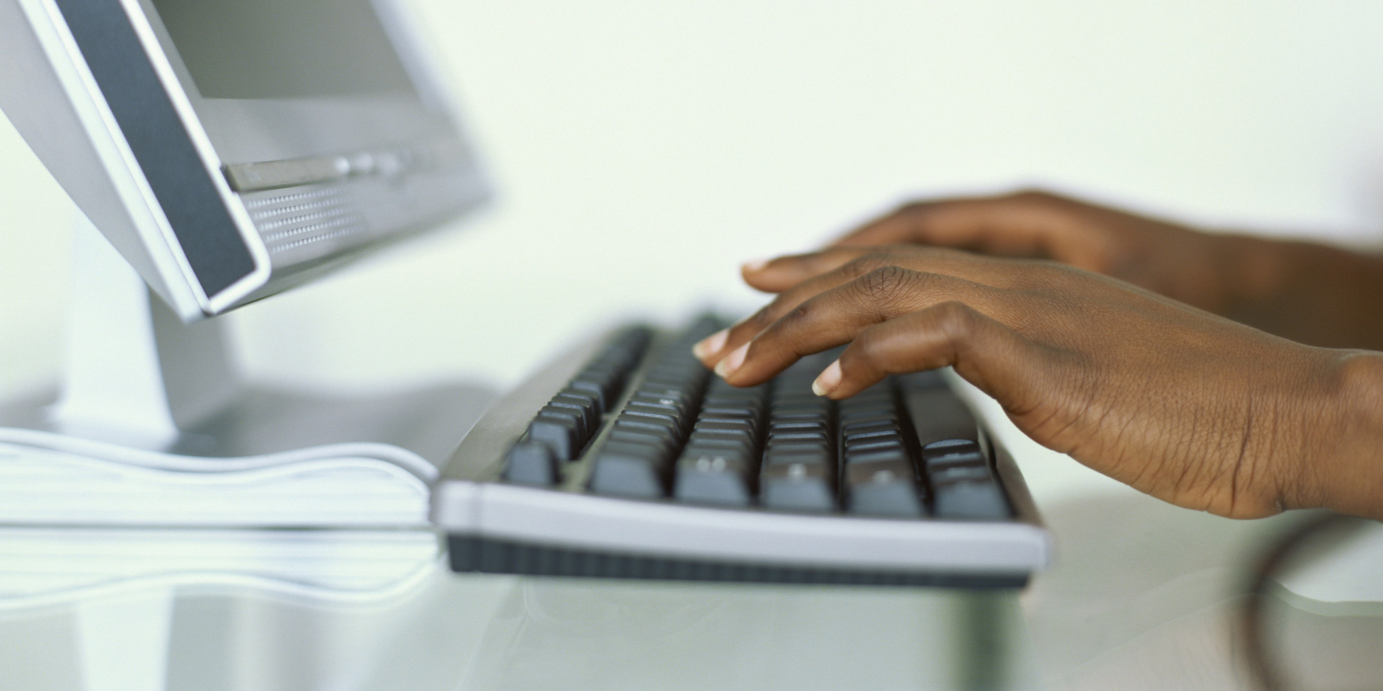 black person typing fingers laptop