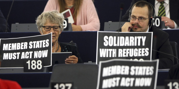 Parliament members display posters while European Commission President Jean-Claude Juncker delivers his State of the Union address at the European Parliament in Strasbourg, eastern France, Wednesday, Sept.9, 2015. Juncker called on EU countries to agree by next week to share 160,000 refugees, warning that Greece, Italy and Hungary can no longer cope alone. (AP Photo/Christian Lutz)