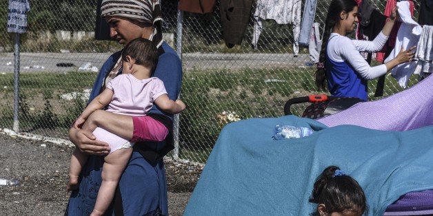 A woman carries her baby at a makeshift refugee camp on the Serbian side of the border with Hungary near the town of Horgos, Sept. 18, 2015. (AFP)