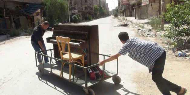 Image du 26 juin 2014 d'Aeham al-Ahmad, poussant son piano à Yarmouk, aux portes de Damas © AFP/Archives RAMI AL-SAYED