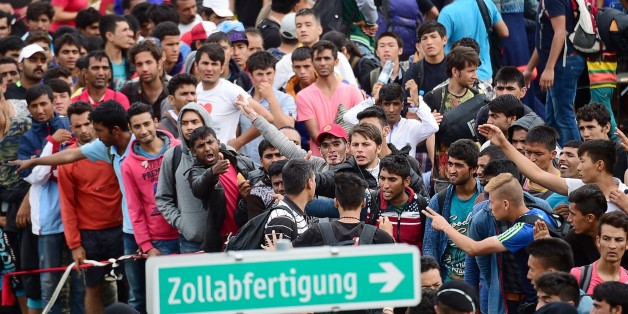 Refugees crowd at the Hungarian-Austrian border in Szentgotthard, Hungary, as thousands of migrants wait for their departure to Germany on September 19, 2015. AFP PHOTO / ATTILA KISBENEDEK (Photo credit should read ATTILA KISBENEDEK/AFP/Getty Images)