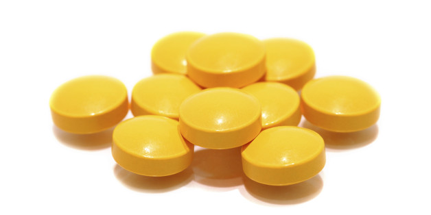 pill of vitamin C on white background.