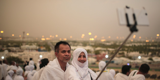 A Muslim pilgrim couple take a selfie on a rocky hill called the Mountain of Mercy, on the Plain of Arafat, near the holy city of Mecca, Saudi Arabia, Tuesday, Sept. 22, 2015. Mount Arafat, marked by a white pillar, is where Islam's Prophet Muhammad is believed to have delivered his last sermon to tens of thousands of followers some 1,400 years ago, calling on Muslims to unite. (AP Photo/Mosa'ab Elshamy)