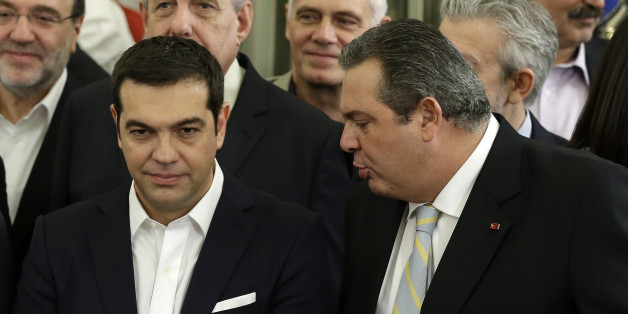 Greece's Prime Minister Alexis Tsipras, left, listens to Greek Defense Minister Panos Kammenos, who heads the government's junior coalition member Independent Greeks during a swearing in ceremony of the cabinet in Athens, Wednesday, Sept. 23, 2015. Greece's new leftist-led coalition government has formally assumed its duties, pledging to enforce creditor-demanded spending cuts and reforms while softening the pain on an austerity-weary population. (AP Photo/Thanassis Stavrakis)
