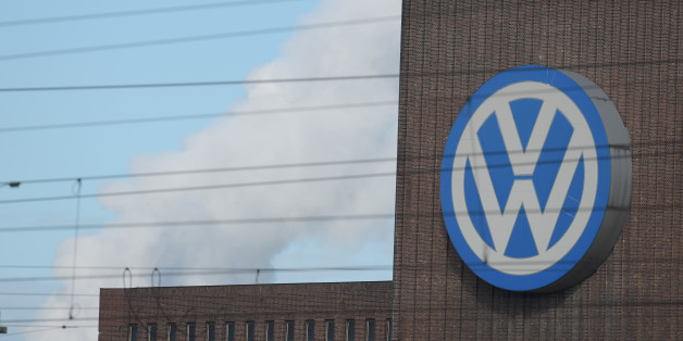 A man looks through binoculars as he stands next to a corporate logo of Volkswagen on the rooftop of the former power plant of the German car manufacturer in Wolfsburg, Germany, Friday, Sept. 25, 2015. Volkswagen's supervisory board is meeting Friday to discuss who to name as CEO after Martin Winterkorn quit the job this week over an emissions-rigging scandal that's rocking the world's top-selling automaker. (Rainer Jensen/dpa via AP)