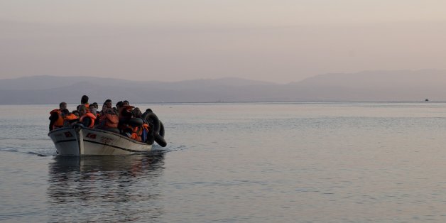 Syrian refugees arrive on a fishing boat from Turkey on the shores of the Greek island of Lesbos , as a helicopter from the European border control agency Frontex flie , Sunday Sept. 27, 2015. More than 260,000 asylum-seekers have arrived in Greece so far this year, most reaching the country's eastern islands on flimsy rafts or boats from the nearby Turkish coast.(AP Photo/Petros Giannakouris)