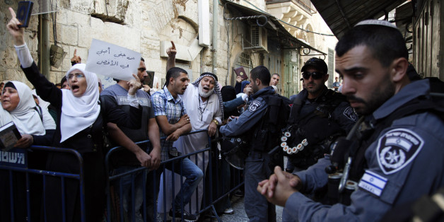 Israeli border police officers stand guard as Palestinians protest in the Old City of Jerusalem on Thursday, Sept. 17, 2015. A rectangular hilltop compound in Jerusalem is ground zero of the Israeli-Palestinian conflict. Known to Muslims as the Noble Sanctuary, it is Islam's third holiest spot. But to Jews it is the Temple Mount, their holiest place. This sensitive arrangement, and attempts to change it, lie at the heart of the unrest that rocked Jerusalem this week. (AP Photo/Mahmoud Illean)