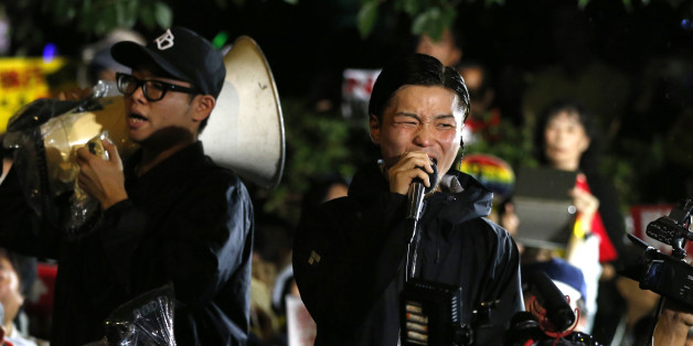 Aki Okuda, center, a leader of the student group known as SEALDs, or Students Emergency Action for Liberal Democracies, shouts slogans during a rally against Japanese government in front of the parliament building in Tokyo, Friday, Sept. 18, 2015. Japan's parliament is moving toward final approval of legislation that would loosen post-World War II constraints placed on its military, an issue that has sparked sizeable street protests and raised fundamental questions about whether the nation needs