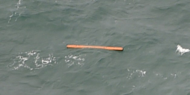 This aerial view taken from an Indonesian search and rescue aircraft over the Java Sea shows floating debris spotted in the same area as other items being investigated by Indonesian authorities as possible objects from missing AirAsia flight QZ8501 on December 30, 2014. Items resembling an emergency slide, plane door and other objects were spotted during a aerial search on December 30 for the missing AirAsia plane, according to information from the flight on which AFP was aboard. AFP PHOTO / Bay ISMOYO (Photo credit should read BAY ISMOYO/AFP/Getty Images)