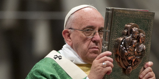 Pope Francis raises the book of the Gospels as he celebrates the opening Mass of the Synod of bishops, in St. Peter's Basilica at the Vatican, Sunday, Oct. 4, 2015. (AP Photo/Alessandra Tarantino)