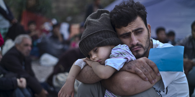 A Syrian refugee child sleeps on his father's arms while waiting at a resting point to board a bus, after arriving on a dinghy from the Turkish coast to the northeastern Greek island of Lesbos, Sunday, Oct. 4 , 2015. The U.N. refugee agency is reporting a ânoticeable dropâ this week in arrivals of refugees by sea into Greece _ as the total figure for the year nears the 400,000 mark. Overall, the UNHCR estimates 396,500 people have entered Greece via the Mediterranean this year with seventy percent of them are from war-torn Syria. (AP Photo/Muhammed Muheisen)