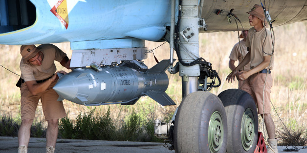 In this photo taken on Saturday, Oct. 3, 2015, Russian military support crew attach a satellite guided bomb to SU-34 jet fighter at Hmeimim airbase in Syria. Russia has insisted that the airstrikes that began Wednesday are targeting the Islamic State group and al-Qaida's Syrian affiliates, but at least some of the strikes appear to have hit Western-backed rebel factions. (AP Photo/Alexander Kots, Komsomolskaya Pravda, Photo via AP)