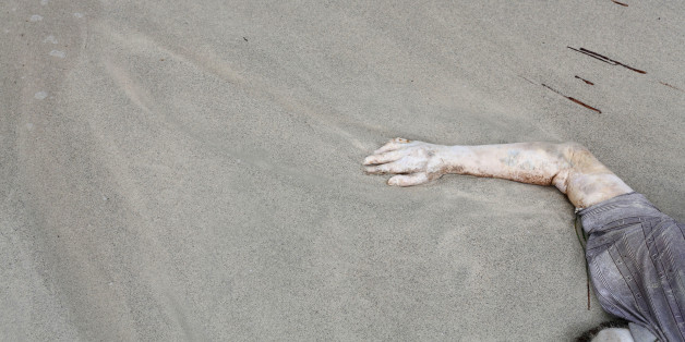In this Monday, Sept. 7, 2015 photo, the body of a drowned man lies on the beach west of the town of Zuwara, Libya. Bodies continue to wash ashore after two fishing boats bound for Europe carrying migrants and refugees capsized off the Libyan coast on Thursday, Aug. 27, 2015. (AP Photo/Mohamed Ben Khalifa)