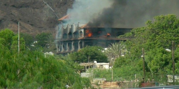 L'hôtel Al-Qasr, où logeait le Premier ministre yéménite, en feu après un attaque à la roquette, le 6 octobre 2015 à Aden