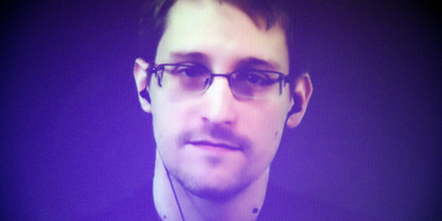 Former U.S. National Security Agency contractor Edward Snowden, who is in Moscow, is seen on a giant screen during a live video conference for an interview as part of Amnesty International's annual Write for Rights campaign at the Gaite Lyrique in Paris, France, Dec. 10, 2014. (AP Photo/Charles Platiau, Pool)