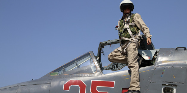 In this photo taken on Saturday, Oct. 3, 2015, Russian army pilot poses at a cockpit of SU-25M jet fighter at Hmeimim airbase in Syria. Russia has insisted that the airstrikes that began Wednesday are targeting the Islamic State group and al-Qaida's Syrian affiliates, but at least some of the strikes appear to have hit Western-backed rebel factions.(AP Photo/Alexander Kots, Komsomolskaya Pravda, Photo via AP)