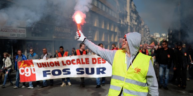 A demonstrator holds a smoke projectile during a National Action Day organised by French labour unions CGT, FSU and Solidaires, on October 8, 2015 in Marseille, to protest against austerity and the French government's social policy. AFP PHOTO / BORIS HORVAT (Photo credit should read BORIS HORVAT/AFP/Getty Images)