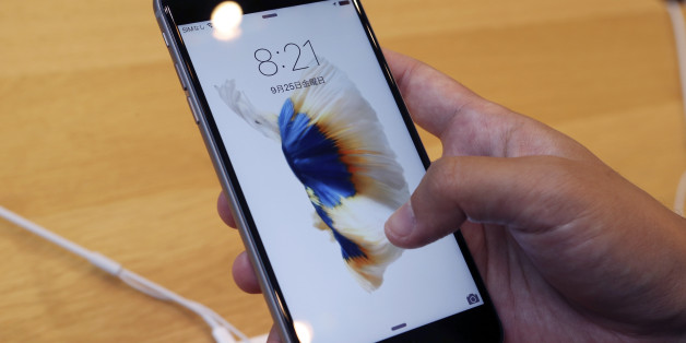 A customer tries new iPhone 6s on display at an Apple store in Tokyo Friday, Sept. 25, 2015. Apple is counting on sales of the new iPhones to maintain its position as one of the most profitable, and valuable, companies in the world. (AP Photo/Koji Sasahara)