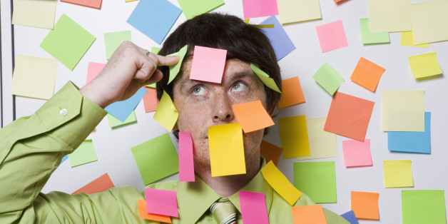 Male office worker covered with sticky notes