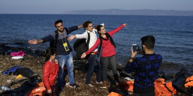 Des réfugiés pausent pour les photographes à leur arrivée sur l'île de Lesbos, le 9 octobre 2015