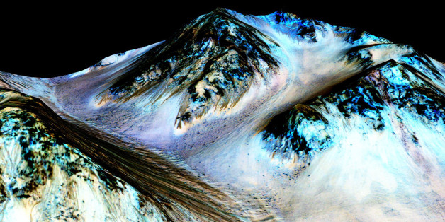 This undated photo provided by NASA and taken by an instrument aboard the agency's Mars Reconnaissance Orbiter shows dark, narrow, 100 meter-long streaks on the surface of Mars that scientists believe were caused by flowing streams of salty water. Researchers said Monday, Sept. 28, 2015, that the latest observations strongly support the longtime theory that salt water in liquid form flows down certain Martian slopes each summer. (NASA/JPL/University of Arizona via AP)