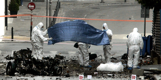 ATHENS, GREECE - APRIL 10: Forensic police examine the scene after a car bomb explosion in central Athens on April 10, 2014 in Athens, Greece. The bomb exploded outside a Bank of Greece building in central Athens before dawn Thursday, causing some damage but no injuries. The blast came hours before Greece was to return to the international bond markets for the first time in four years, and a day before German Chancellor Angela Merkel was to visit Athens. (Photo by Milos Bicanski /Getty Images)