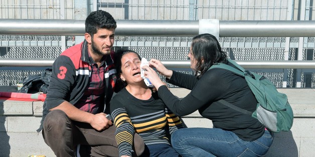 A woman is helped following an explosion at the main train station in Turkey's capital Ankara, on October 10, 2015. At least 20 people were killed in the explosion which happened ahead of an anti-government peace rally organised by leftist groups later in the day, including the pro-Kurdish Peoples' Democratic Party (HDP). AFP PHOTO / ADEM ALTAN (Photo credit should read ADEM ALTAN/AFP/Getty Images)