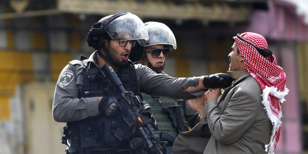A Palestinian is pushed an Israeli policemen amid clashes in Hebron, West Bank, Saturday, Oct. 10, 2015. A Palestinian teenager stabbed two Israelis in Jerusalem Saturday before being shot dead by police forces, the latest in a series of stabbing attacks against civilians and soldiers that have spread across Israel and the West Bank in the past week. The violence, including the first apparent revenge attack by an Israeli Friday and increasing protests by Israel's own Arab minority, has raised fe